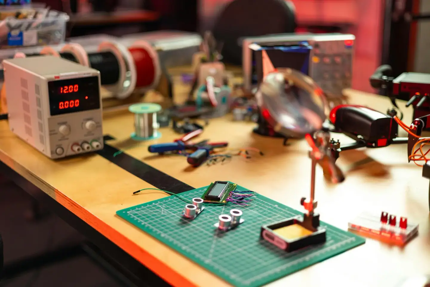 Electronics workbench with hand tools, repair mat, and small components laid out for easy access